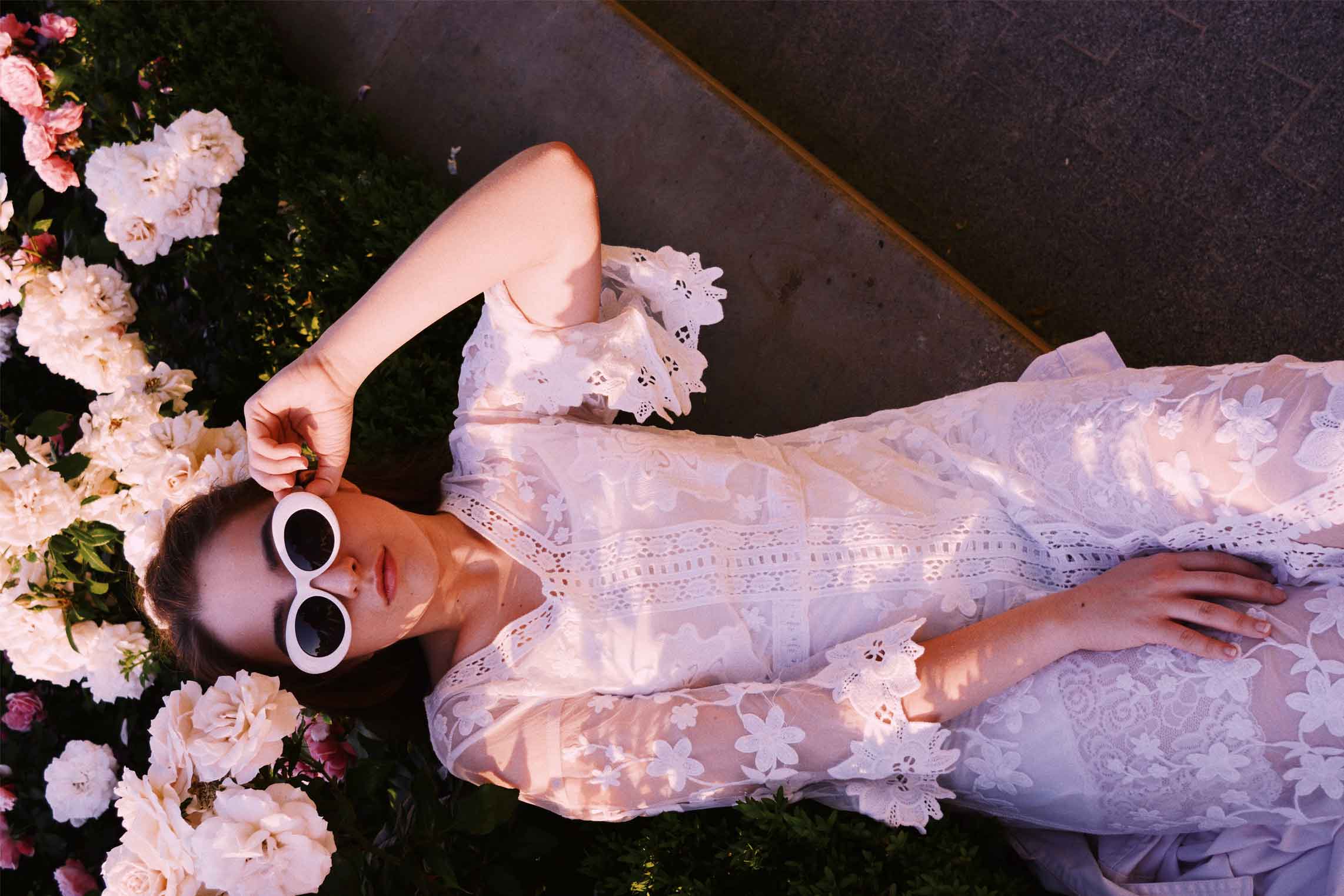 Imagen para estrategia de marketing digital de mujer posando con un vestido blanco y gafas de sol.